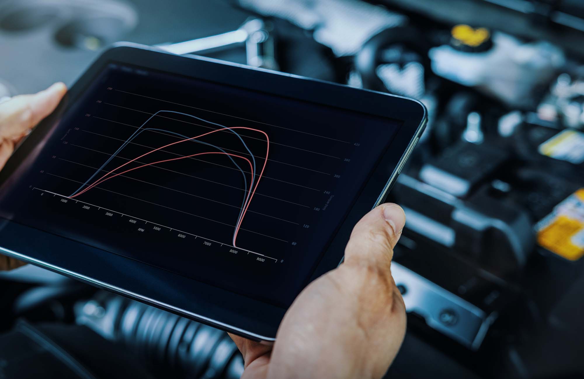 Car engine ecu remapping and diagnostics. mechanic using digital tablet to check vehicle performance after chiptuning
